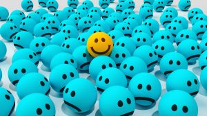 Light blue balls with smiley faces, some happy and some sad.
