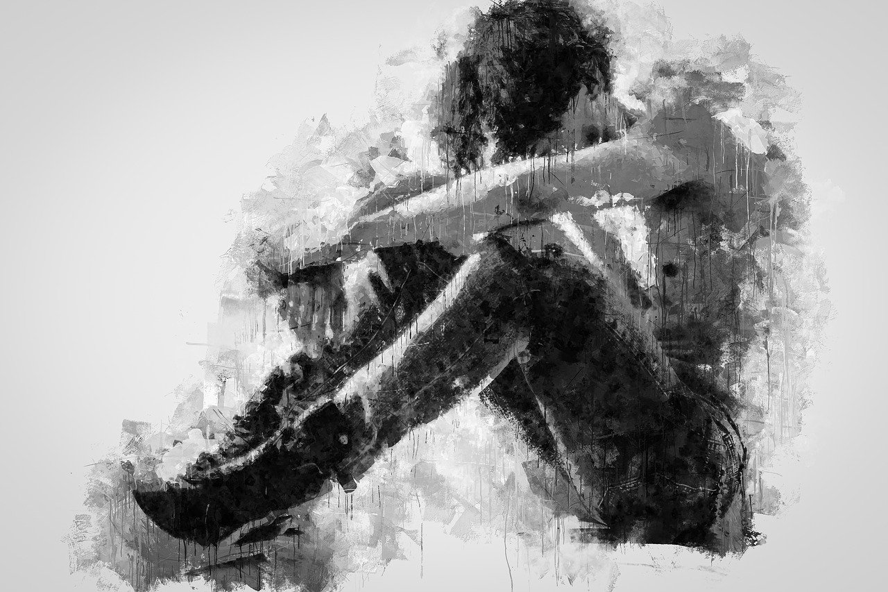 Black and white oil portrait of a young man with his head between his arms reflecting states of sadness, depression and anxiety.